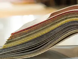 Fanned stack of flooring fabric swatches in assorted colours